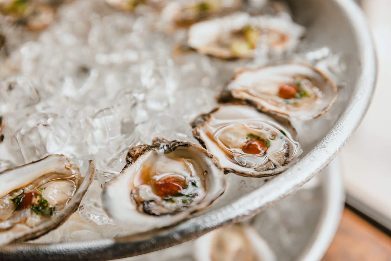 About Close-up of fresh oysters served on a bed of crushed ice, perfect for seafood lovers.
