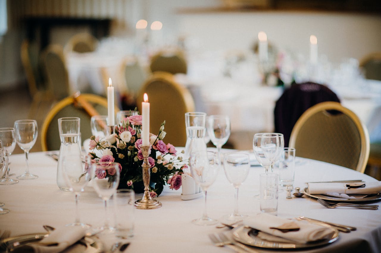 Home Elegant table setting for a wedding with a floral centerpiece and candles.