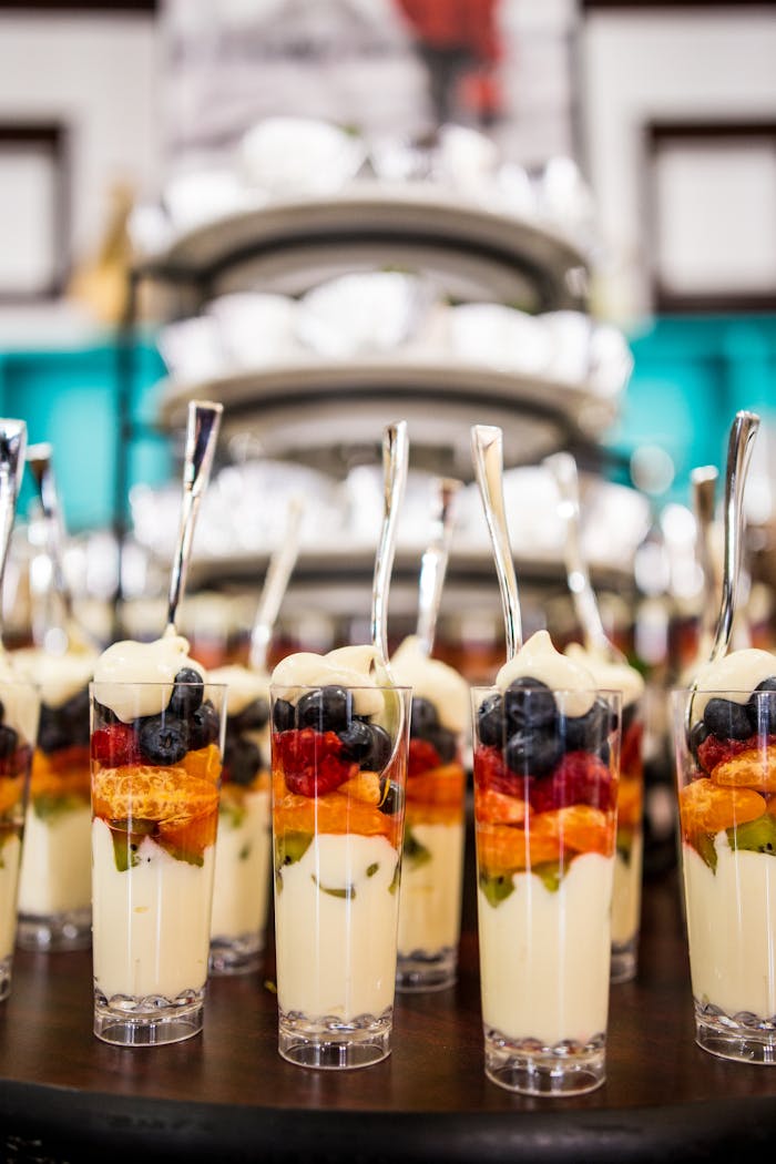 Contact Layered fruit parfaits with yogurt and fresh berries served in elegant glasses.