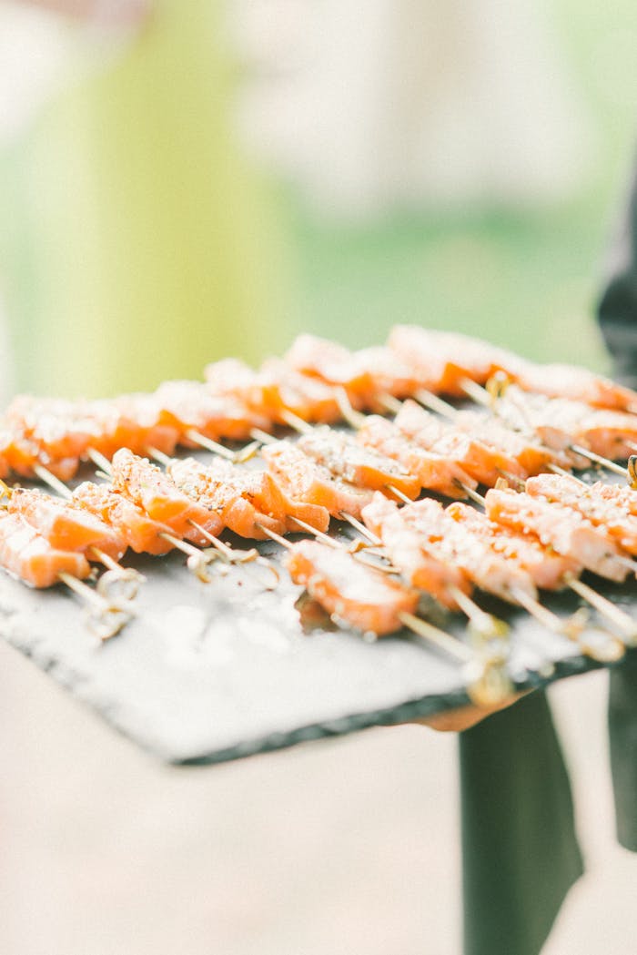 Services Close-up of gourmet salmon skewers served on a slate platter. Ideal for catering and events.